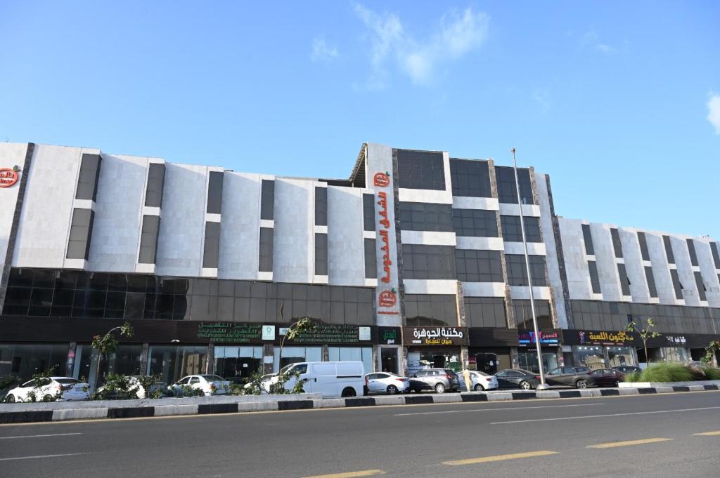 a large building with cars parked in front of it at بالمر للشقق المخدومة in Jazan