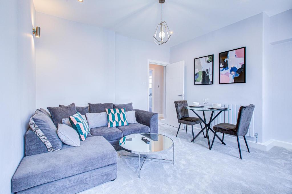 a living room with a couch and a table at Artsy Serviced Apartments - Victoria in London