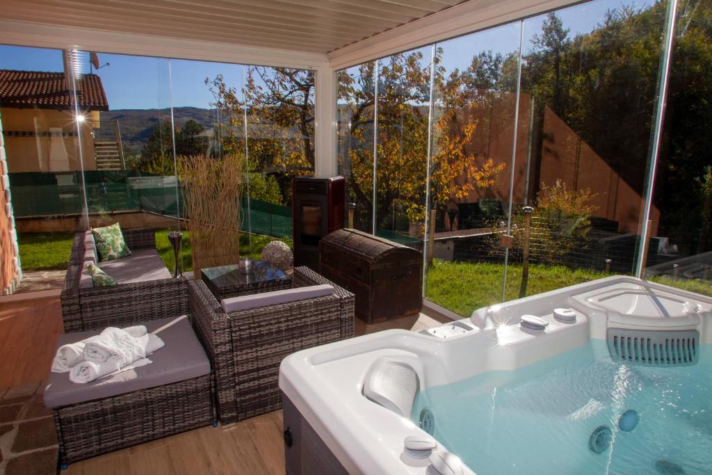 uma banheira de hidromassagem num pátio com vista em Modern Villa with jacuzzi and sauna near Tuscany em Monghidoro