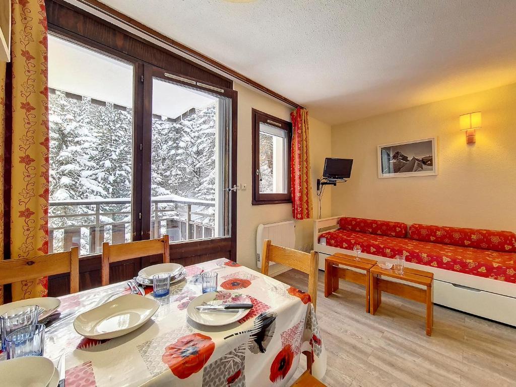- un salon avec une table, un canapé et une fenêtre dans l'établissement Studio cosy au pied des pistes avec balcon à 24 Rue du Panorama, Les Belleville - FR-1-344-884, aux Menuires
