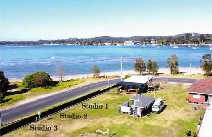 eine Luftansicht auf einen Strand mit einem LKW und einem Gebäude in der Unterkunft Beachside Bungalows in Batemans Bay