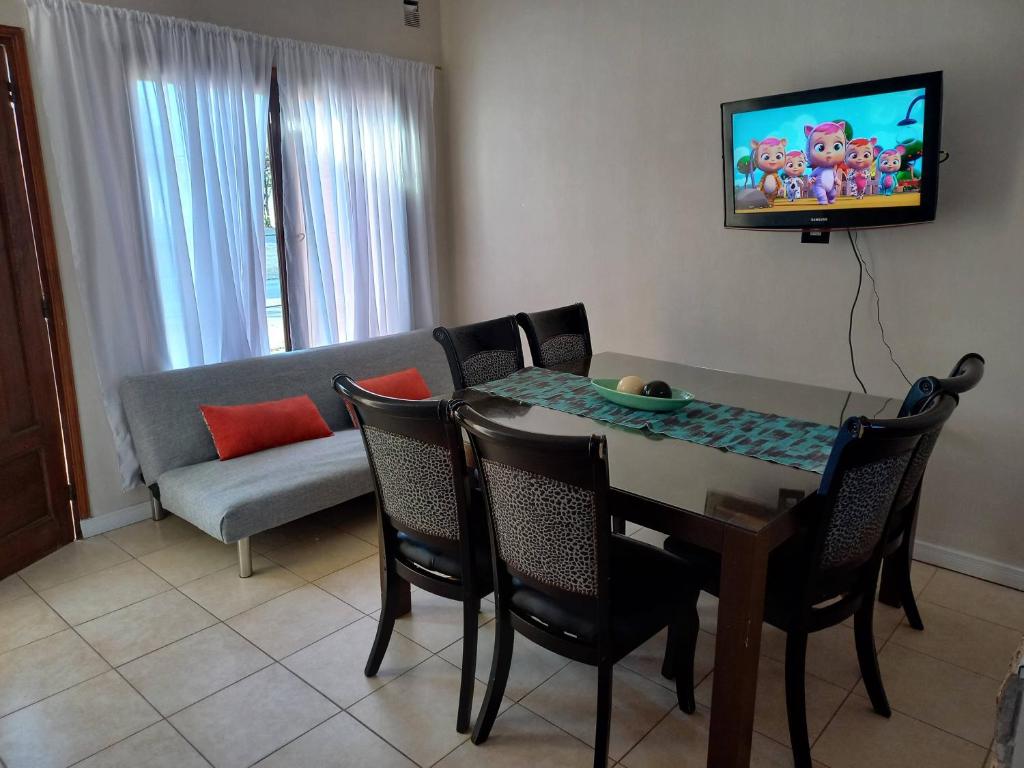 sala de estar con mesa, sillas y sofá en Apart LAS HERAS en Río Cuarto