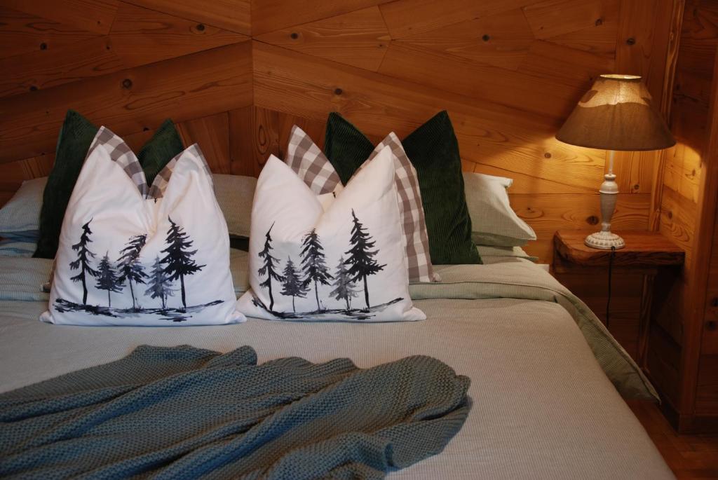 una camera da letto con un letto con alberi di pino sui cuscini di Ca de Vej a Nus