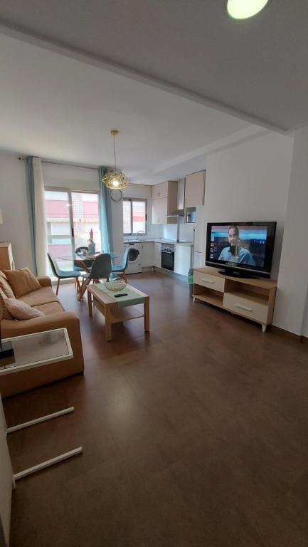 a living room with a couch and a flat screen tv at Apartamento moderno vacacional in Águilas