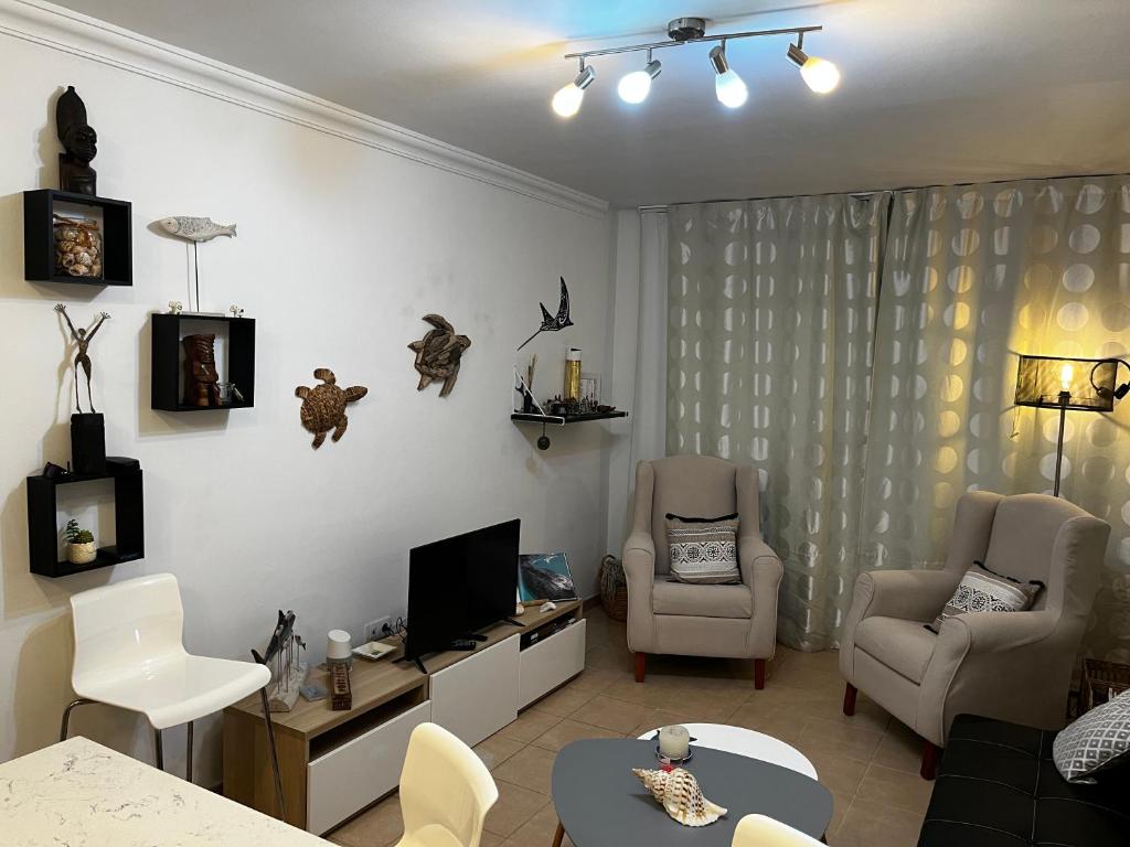 - un salon avec deux chaises et une télévision dans l'établissement Casa del Buzo, à Tías