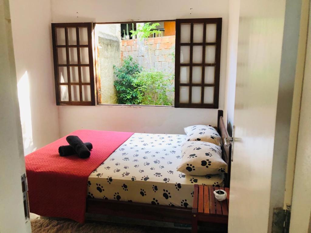 ein Schlafzimmer mit einem Bett mit Kissen und einem Fenster in der Unterkunft Casa no paraíso Búzios! in Búzios