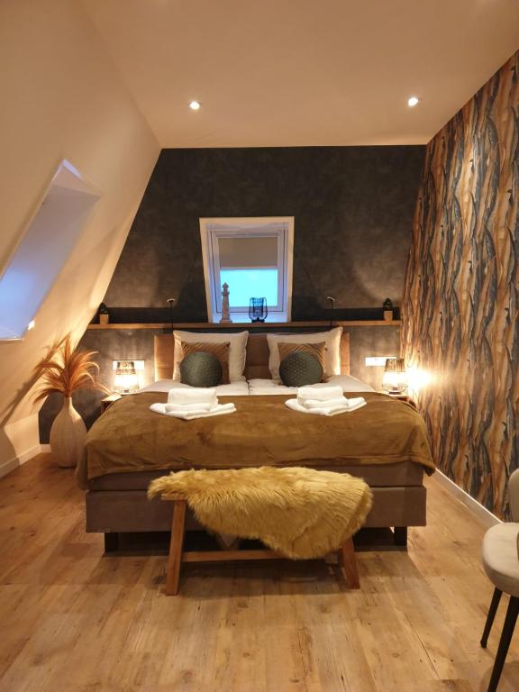 a bedroom with a large bed and a window at Suite De Brinkparel in De Koog