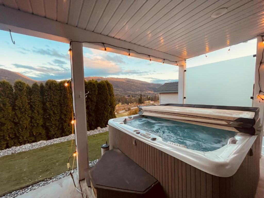 a hot tub on a patio with a view at Relaxing 3 bedroom suite, near Silver Star Resort in Vernon