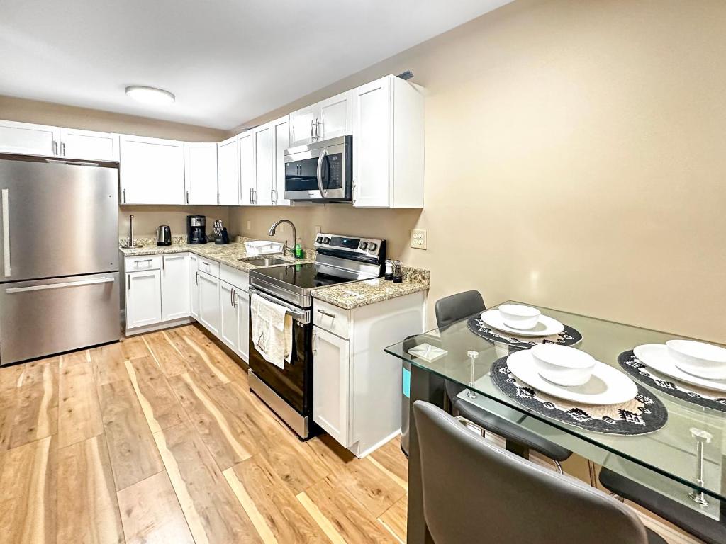 a kitchen with white cabinets and a table with chairs at Cozy Brockton Nook in Brockton