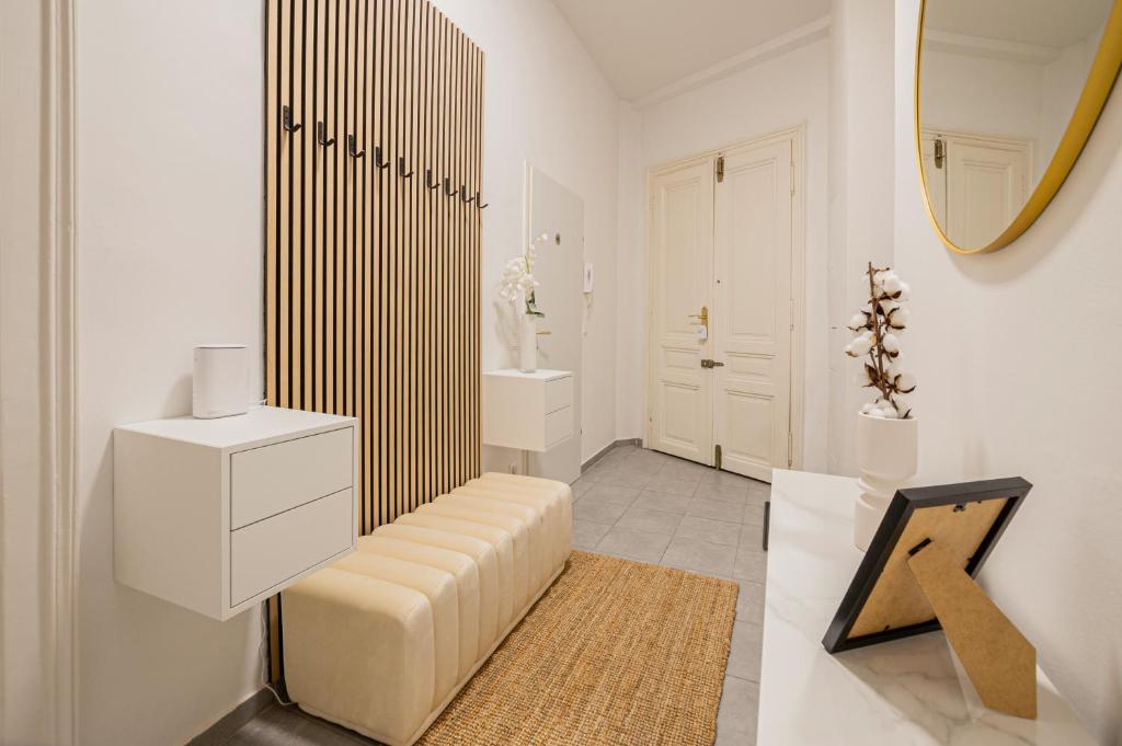 a white bathroom with a bench and a mirror at Charming APT perfect for 4-6 tram, self-checkin in Vienna