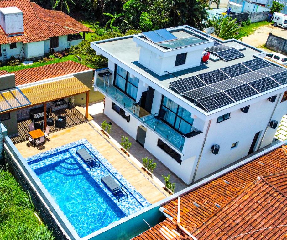 an aerial view of a house with solar panels on the roof at Home Aguas da barra Ilhabela in Ilhabela