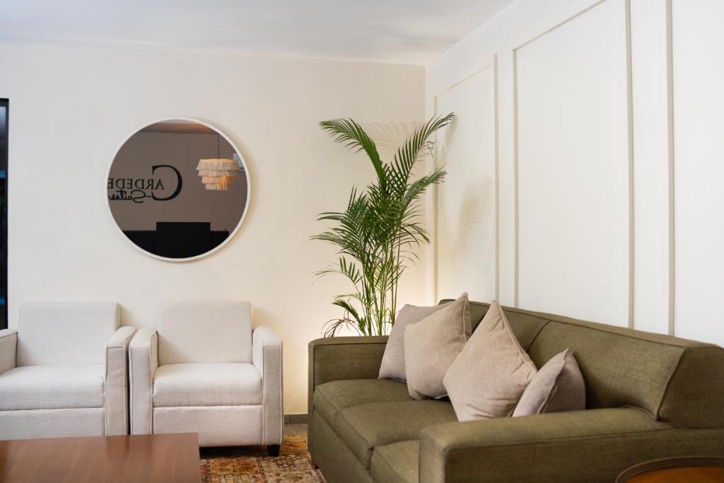 Cardedeu Suites في سان سلفادور: غرفة معيشة مع أريكة وكرسي