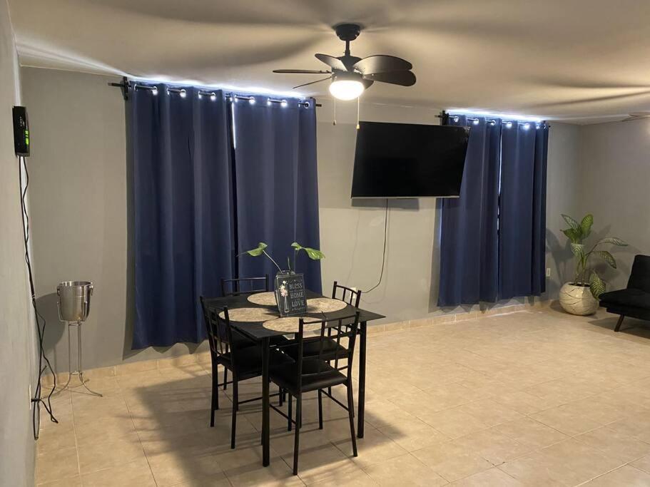 ein Esszimmer mit einem Tisch und blauen Vorhängen in der Unterkunft Casa Ciruelos Relax Confort and Relax in Ciudad Madero