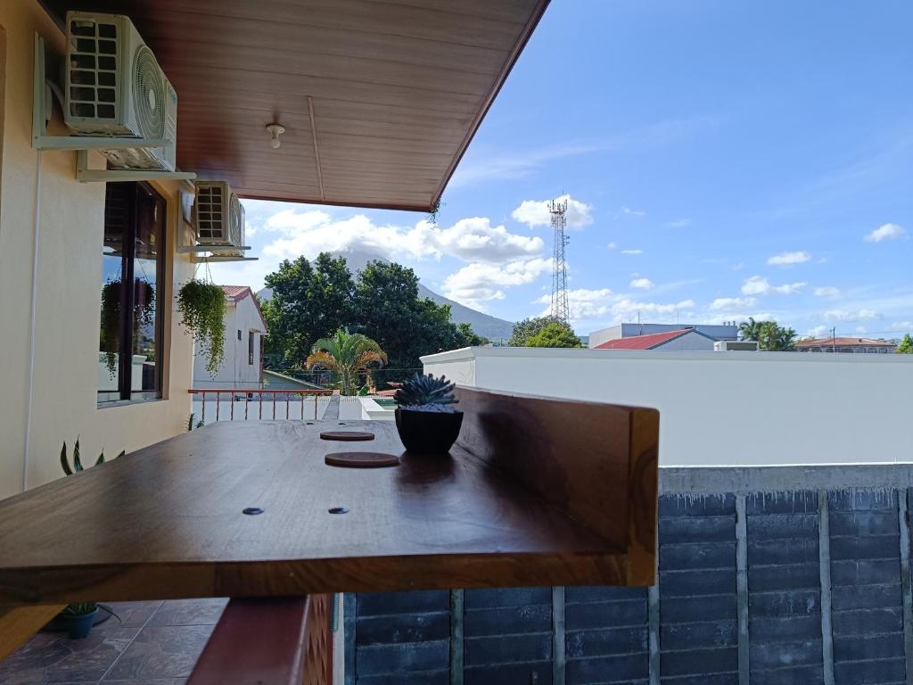 un tavolo in legno su un patio con vista su una casa di Arenal Paradise Lodge a Fortuna