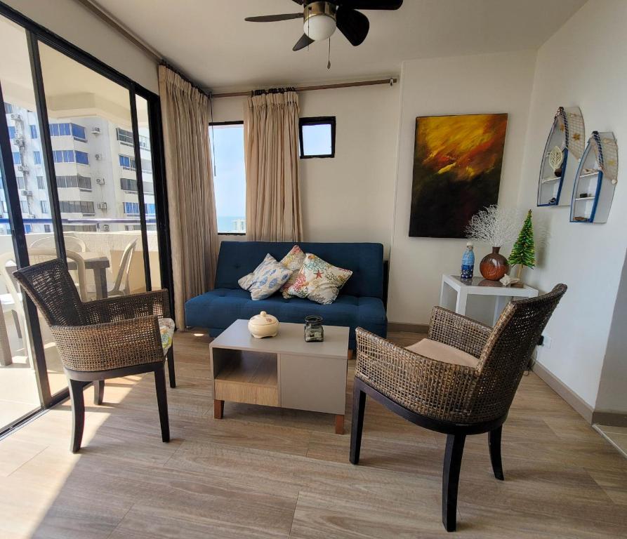 sala de estar con sofá azul y sillas en Edificio Marina del Rey Cartagena, en Cartagena de Indias