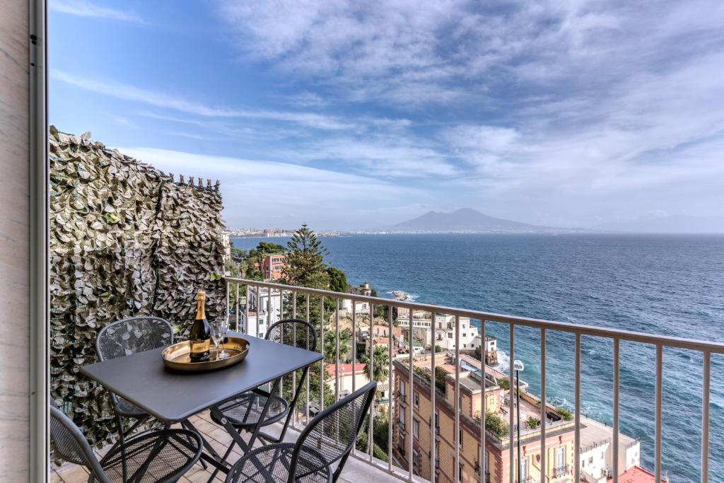 balcone con tavolo, sedie e vista sull'oceano di 1000 Suites a Napoli