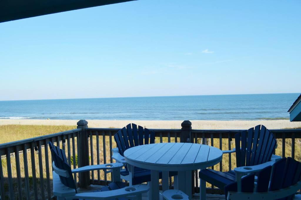 una mesa y sillas en un balcón con vistas a la playa en Living the Dream on the beach! en Carolina Beach