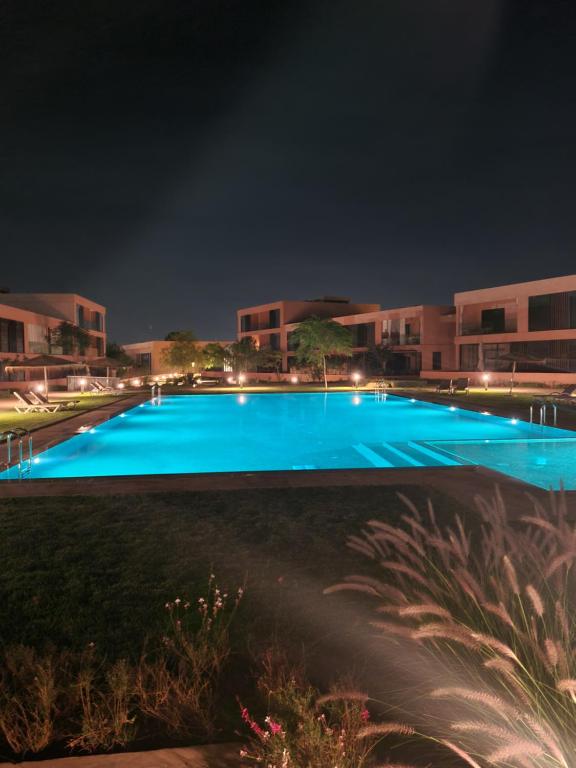 una gran piscina azul por la noche en Appartement sublime piscine Marrakech, en Marrakech