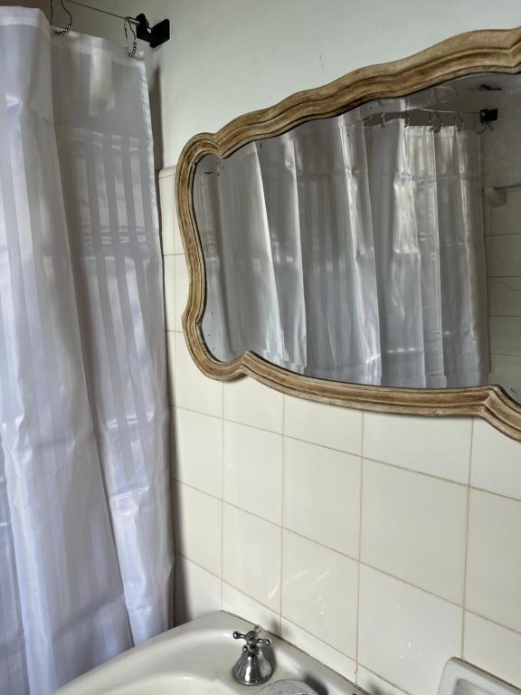 uma casa de banho com um lavatório e um espelho em El_Ceibo_Lobos em Lobos