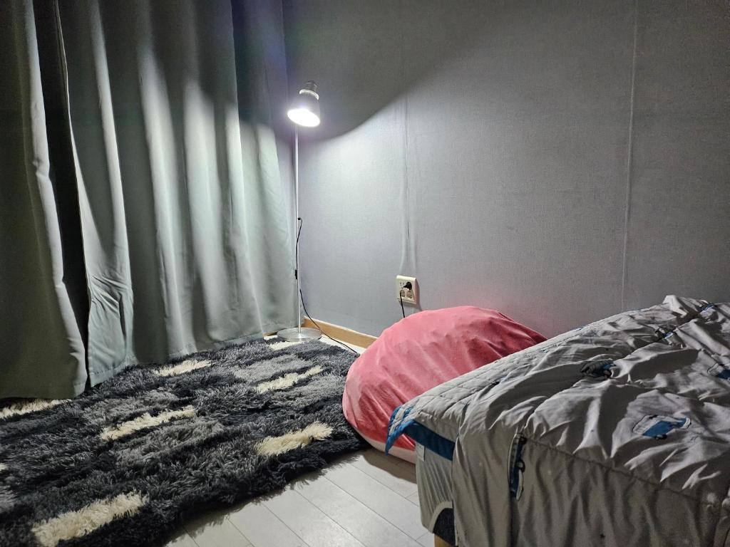 a bedroom with a bed and a light on the wall at Urban Space Sinnonhyeon in Seoul