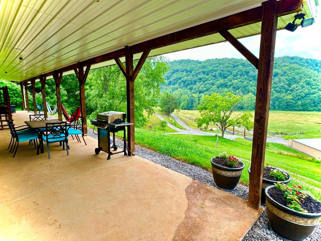 un patio cubierto con mesa, sillas y parrilla en Country views and hikes., en Kyles Ford