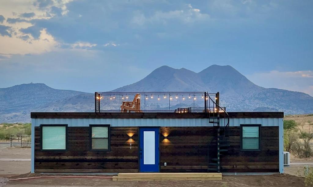 un bâtiment avec un balcon donnant sur les montagnes en arrière-plan dans l'établissement New Southwest Shipping Container-In Alpine, à Alpine
