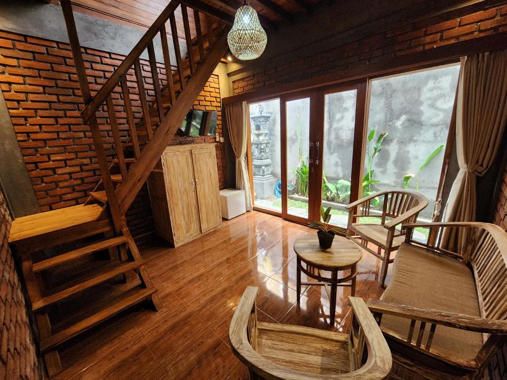 a room with a staircase and a table and chairs at Jineng Guest house by the swand in Dalung