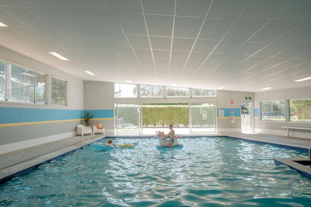 2 enfants sont assis dans une piscine dans l'établissement Port Fairy Holiday Park, à Port Fairy