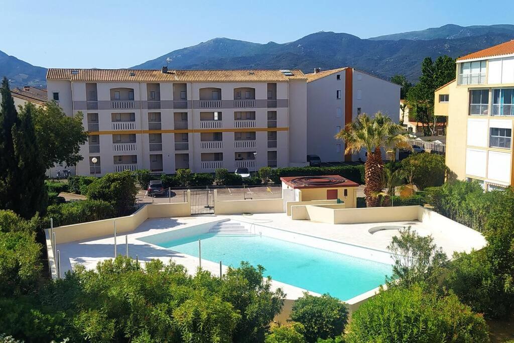 uma grande piscina em frente a um edifício em Piscine - mer 5 minutes à pied - sans draps em Argelès-sur-Mer