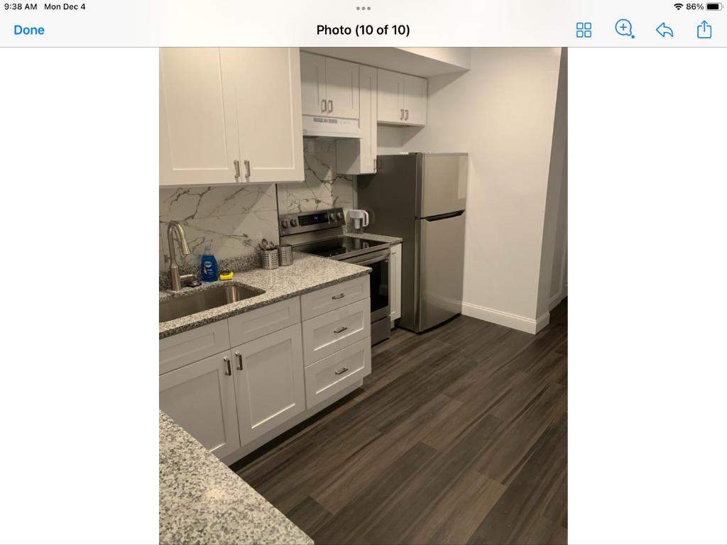 a kitchen with white cabinets and a stainless steel refrigerator at Stylist bedroom central of Baltimore in Baltimore