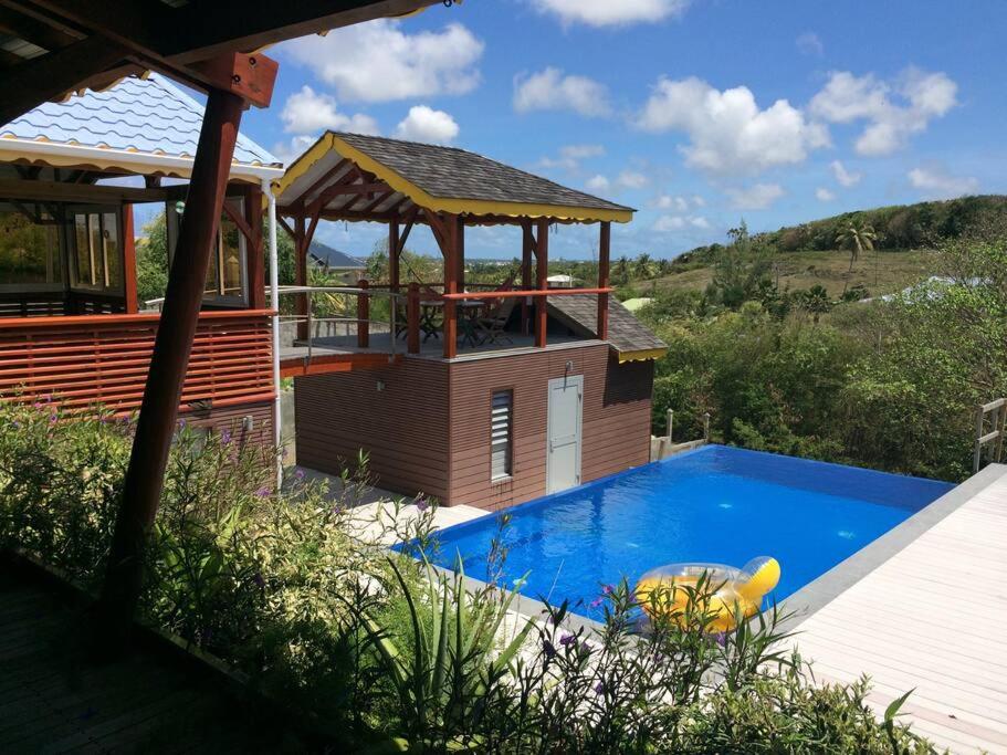 a house with a pool and a gazebo at Villa Atypique - Charme & Confort in Le Moule