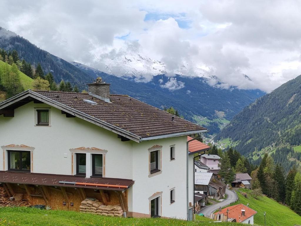 a house on a hill with mountains in the background at Ferienhaus Wolf in Tobadill