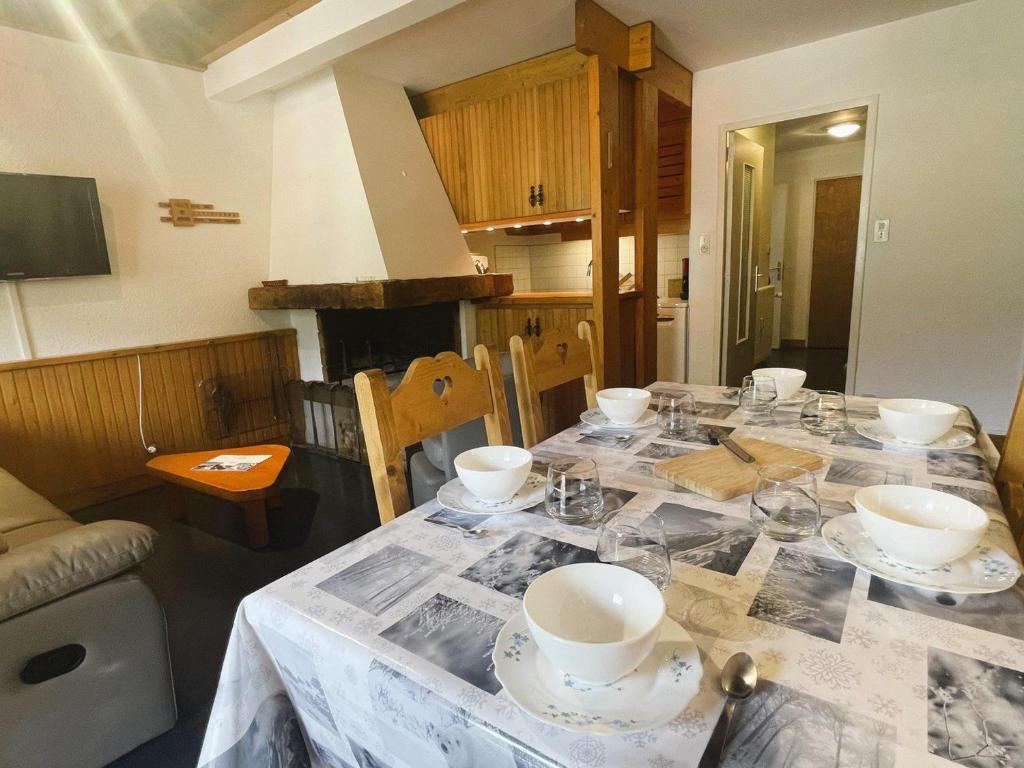 a table with plates and bowls on top of it at Appartement Méribel, 2 pièces, 6 personnes - FR-1-411-863 in Les Allues