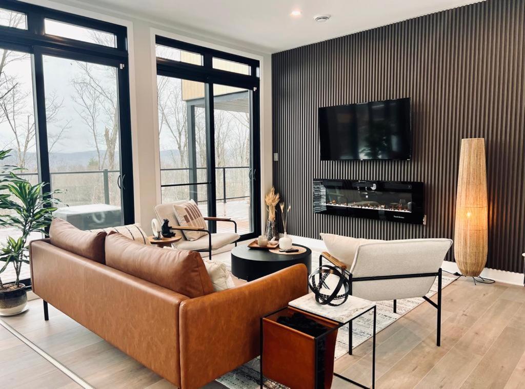 a living room with a couch and chairs and a tv at The Golden View - Luxury Cottage in La Conception