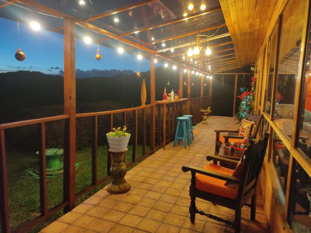un porche cubierto con luces y sillas en Balcones del Lago de Tota, en Sogamoso