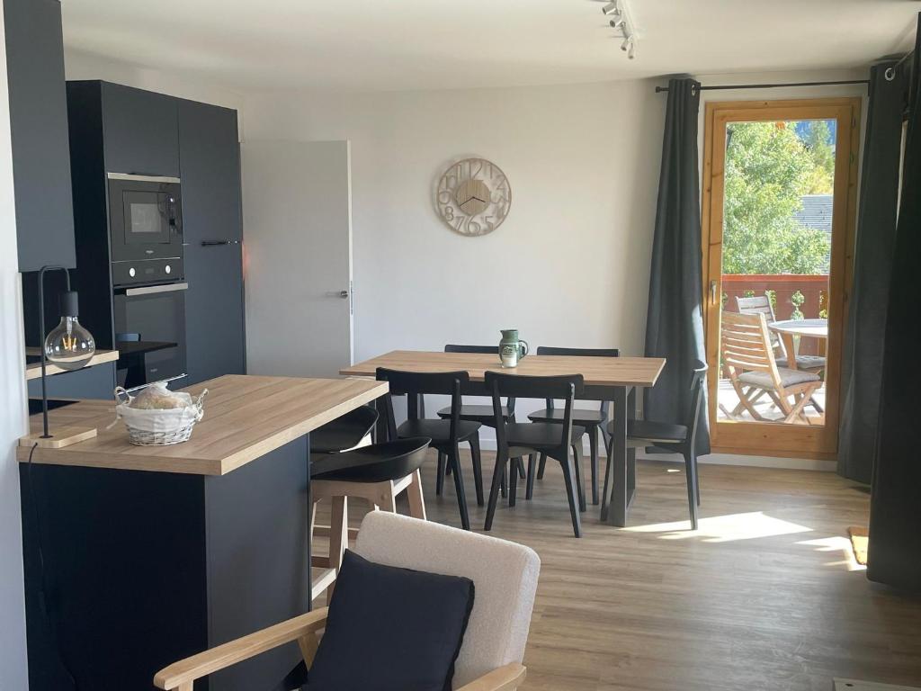 eine Küche und ein Esszimmer mit Tisch und Stühlen in der Unterkunft Appartement de charme 4 pièces, 8 pers, balcon, proche pistes et centre, Vallandry - FR-1-411-875 in Landry