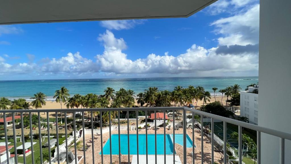 a view of the beach from the balcony of a resort at Beach front 2 bedroom & bath in Isla Verde in San Juan