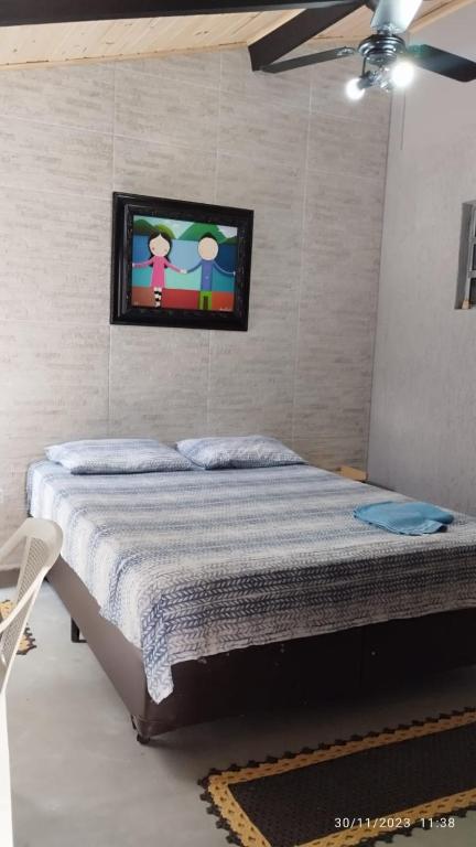 a bedroom with a bed with a tv on the wall at Hospedagem Em Santana de Parnaíba in Santana de Parnaíba