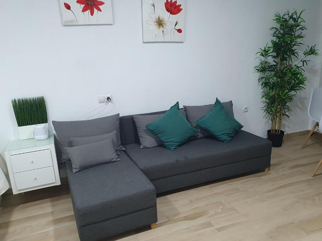 a living room with a gray couch with blue pillows at Apartamento Vistas al mar in Torremolinos