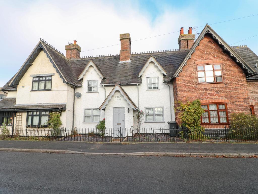 a large white house with a black fence at 7 The Village in Ilkeston