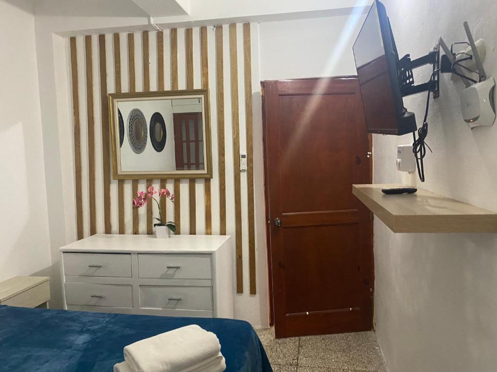 łazienka z łóżkiem, umywalką i telewizorem w obiekcie Apartamentos Magallanes Romana w mieście La Romana