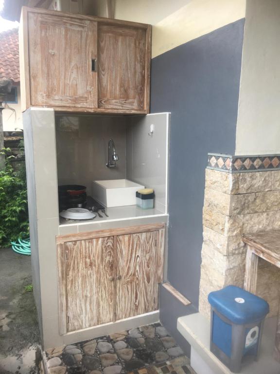 een keuken met houten kasten en een wastafel bij Artawa House in Ubud