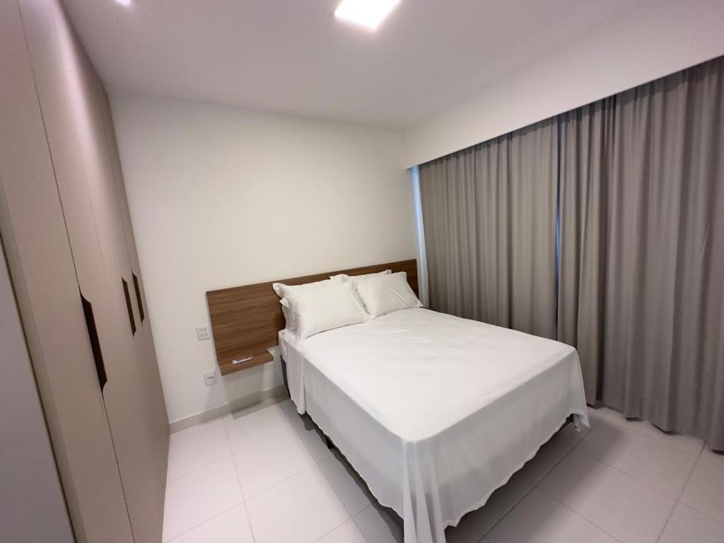 ein Schlafzimmer mit einem weißen Bett in einem Zimmer in der Unterkunft Mana Beach Experience -02Garagens - Aloha 001 in Ipojuca