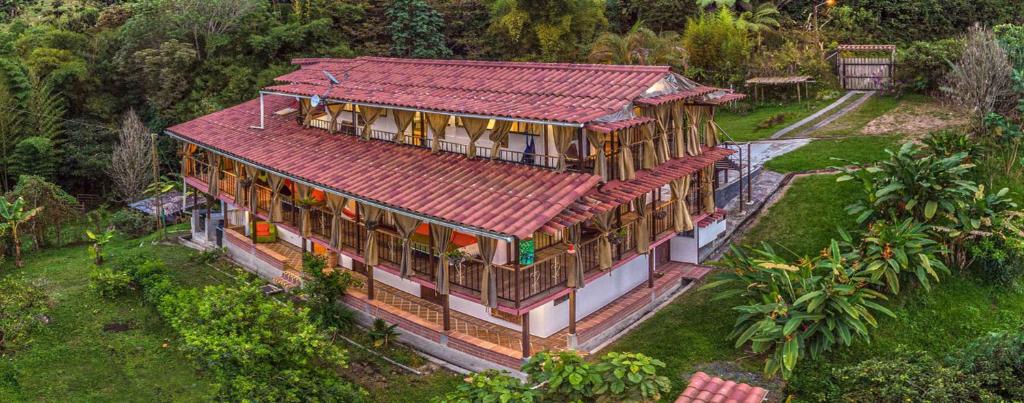 einen Blick über ein Haus mit rotem Dach in der Unterkunft Kairí Lodge Natural Reserve in Manizales