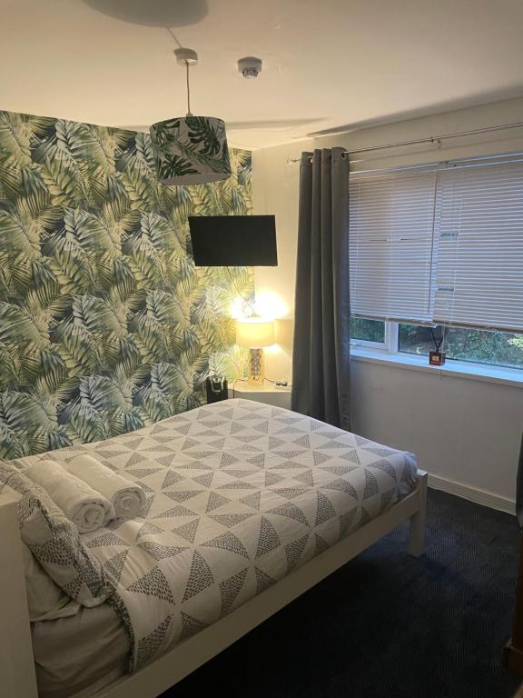 Henwick的住宿－The Swan Inn，一间卧室配有一张床,墙上贴有 ⁇ 萝壁纸