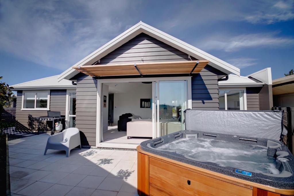 a hot tub on a patio in front of a house at The Gallery in Rotorua