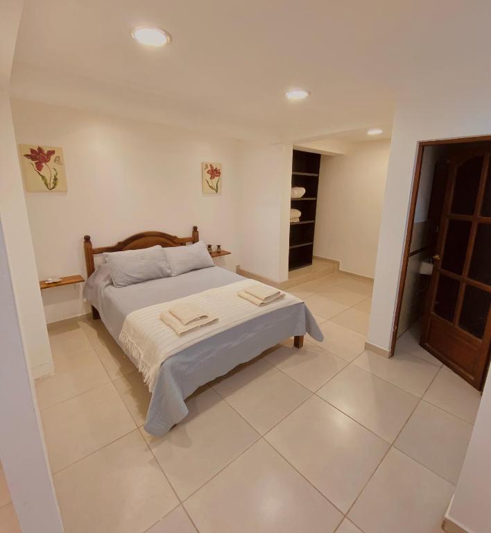 1 dormitorio con 1 cama y suelo de baldosa en Departamento Cinco Hermanos en Ushuaia
