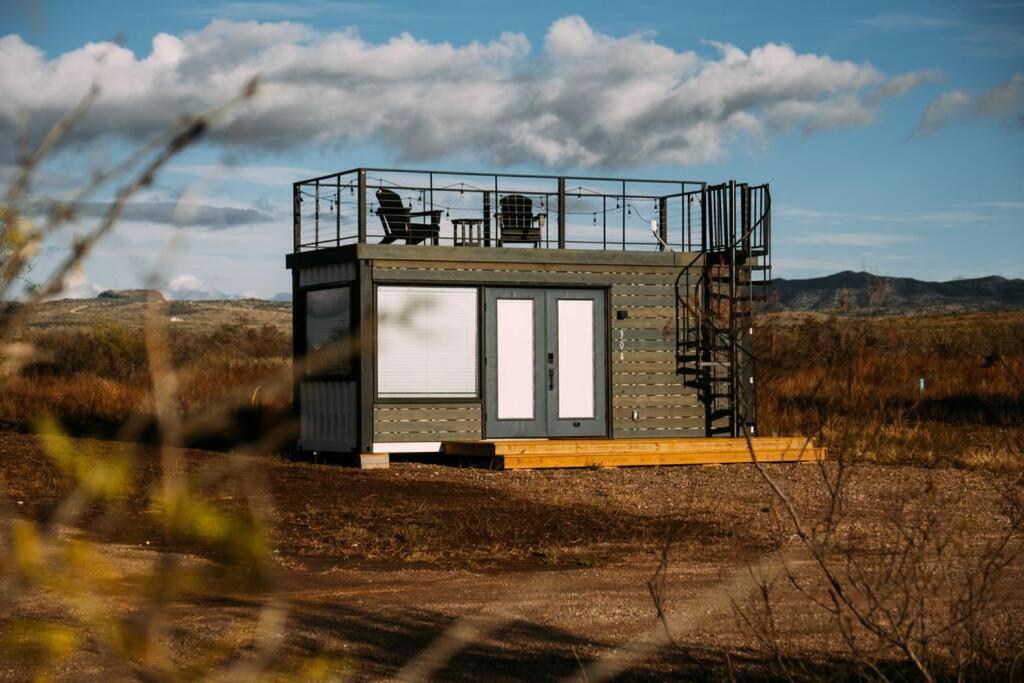 a tiny house sitting in the middle of a field at New Cowgirl Shipping Container Home in Alpine