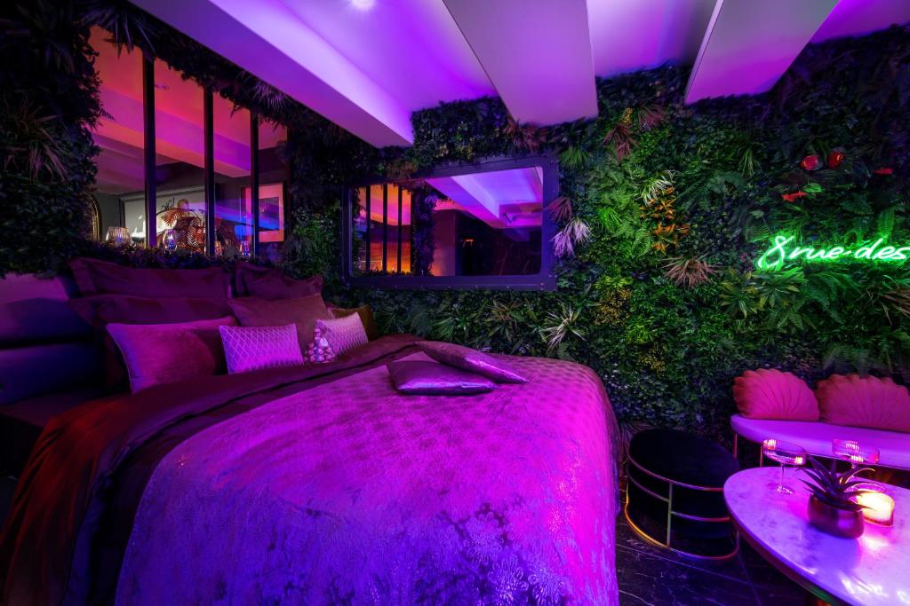 a purple room with a bed and a table at Love room “La nuit de rêve” centre historique in Perpignan