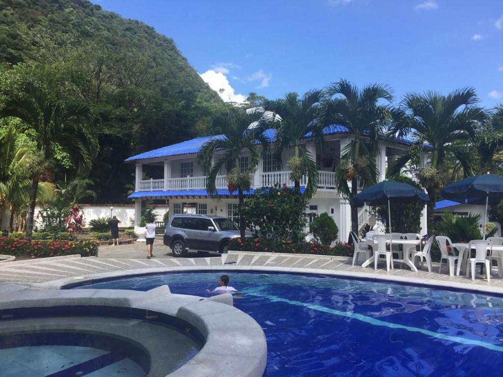 una persona in una piscina di fronte a una casa di Quinta El Diamante a Villavicencio